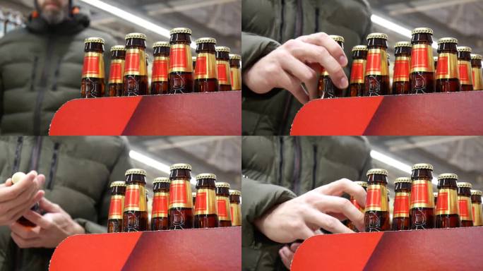 啤酒专柜里许多金红色啤酒瓶的特写镜头，一位男顾客拿了两个