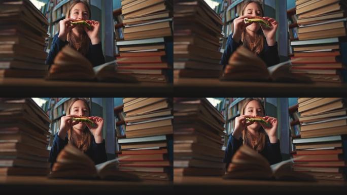 一个女学生在图书馆上课时吃起司三明治。大学教育。在图书馆用书自学。