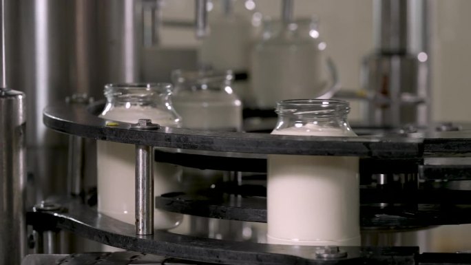 装在玻璃罐里的蛋黄酱正在生产线上移动。
