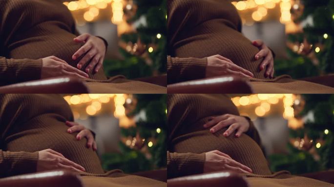一个怀孕的女人和她的宝宝度过她的第一个圣诞节，年轻的准妈妈抱着怀孕的肚子里的孩子