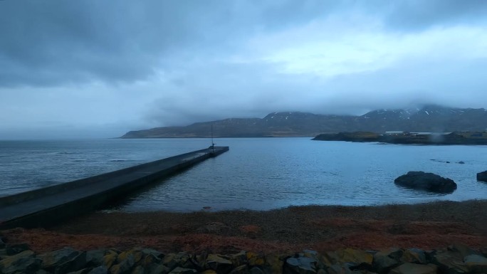 冰岛Bakkagerdi峡湾的夜晚景观，混凝土码头延伸到海湾。