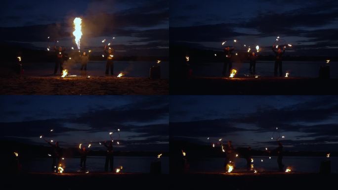 一组专业特技人员在夏夜的河滩上表演消防表演