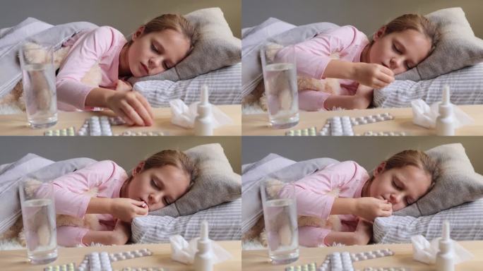 孩子的药。生病的小女孩躺在床上，忍受着高温，看起来不健康，不开心，吃药需要吃药来治疗她的感冒。