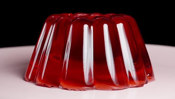 红色果冻在盘子里颤抖，在特写镜头中旋转。