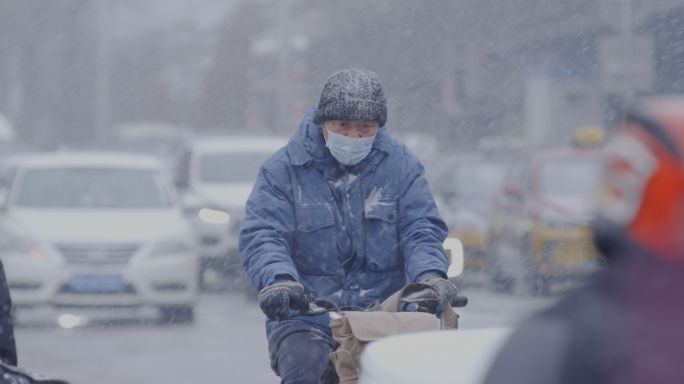 北京街头下雪天行人行走羽绒服出行市井大雪