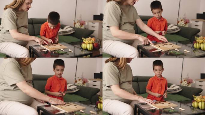 母亲和儿子在家里玩木制玩具