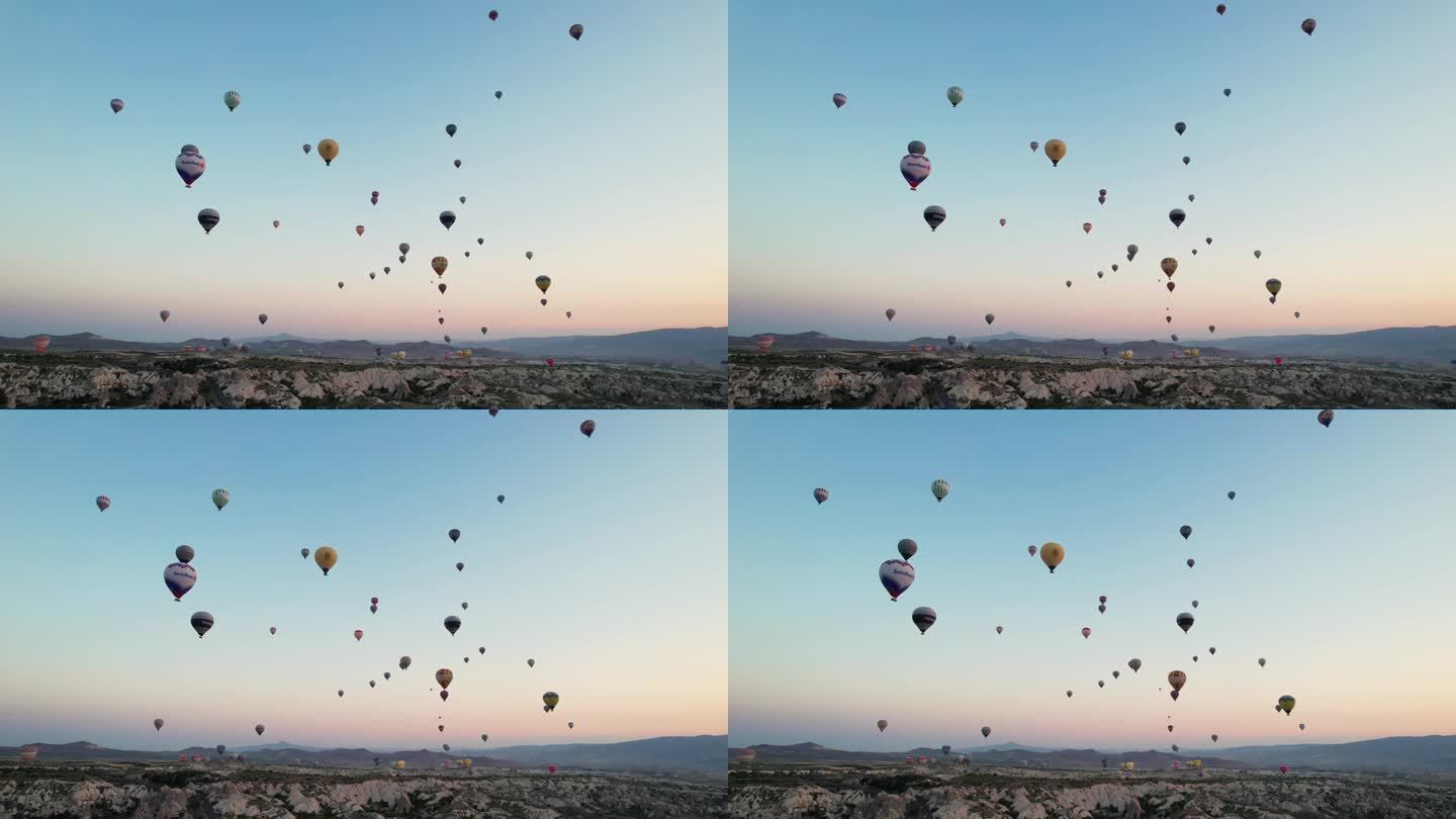在土耳其，太阳和气球一起升起。空中有很多气球。