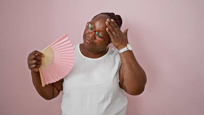 非裔美国妇女用手扇为孤立的粉红色背景热痛苦