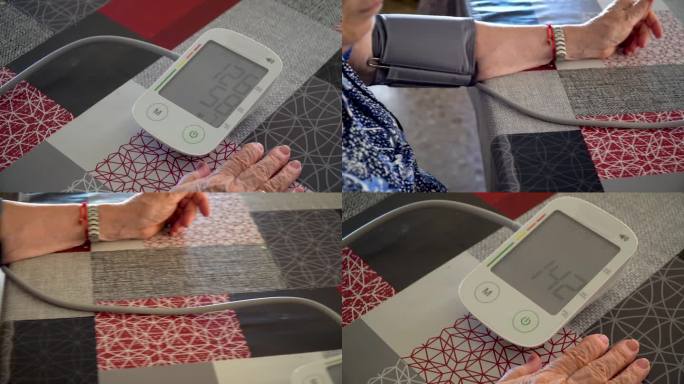 一位老妇人在家里用数字监测仪测量血压。
