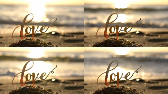 “爱”字的黑色轮廓在黎明和日落的海边海浪的背景。用文字勾勒出爱的轮廓，用落日和旭日的沙。概念爱情迷恋
