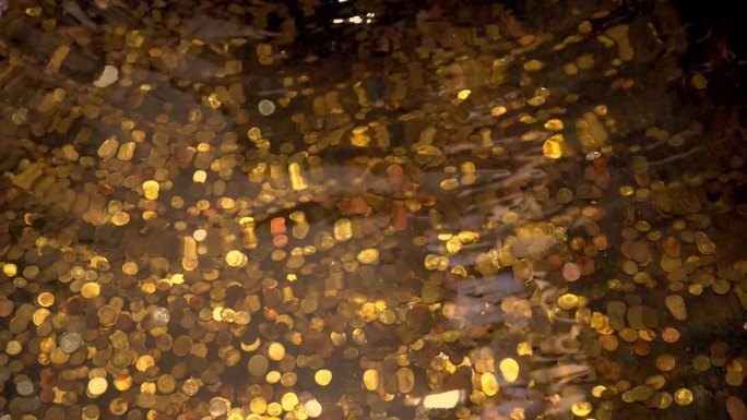 海底的宝藏。金币在水下。喷泉里有很多硬币。海浪和水的摇摆运动。