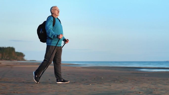 积极爷爷斯堪的纳维亚手杖体育活动在森林沙滩海边日落