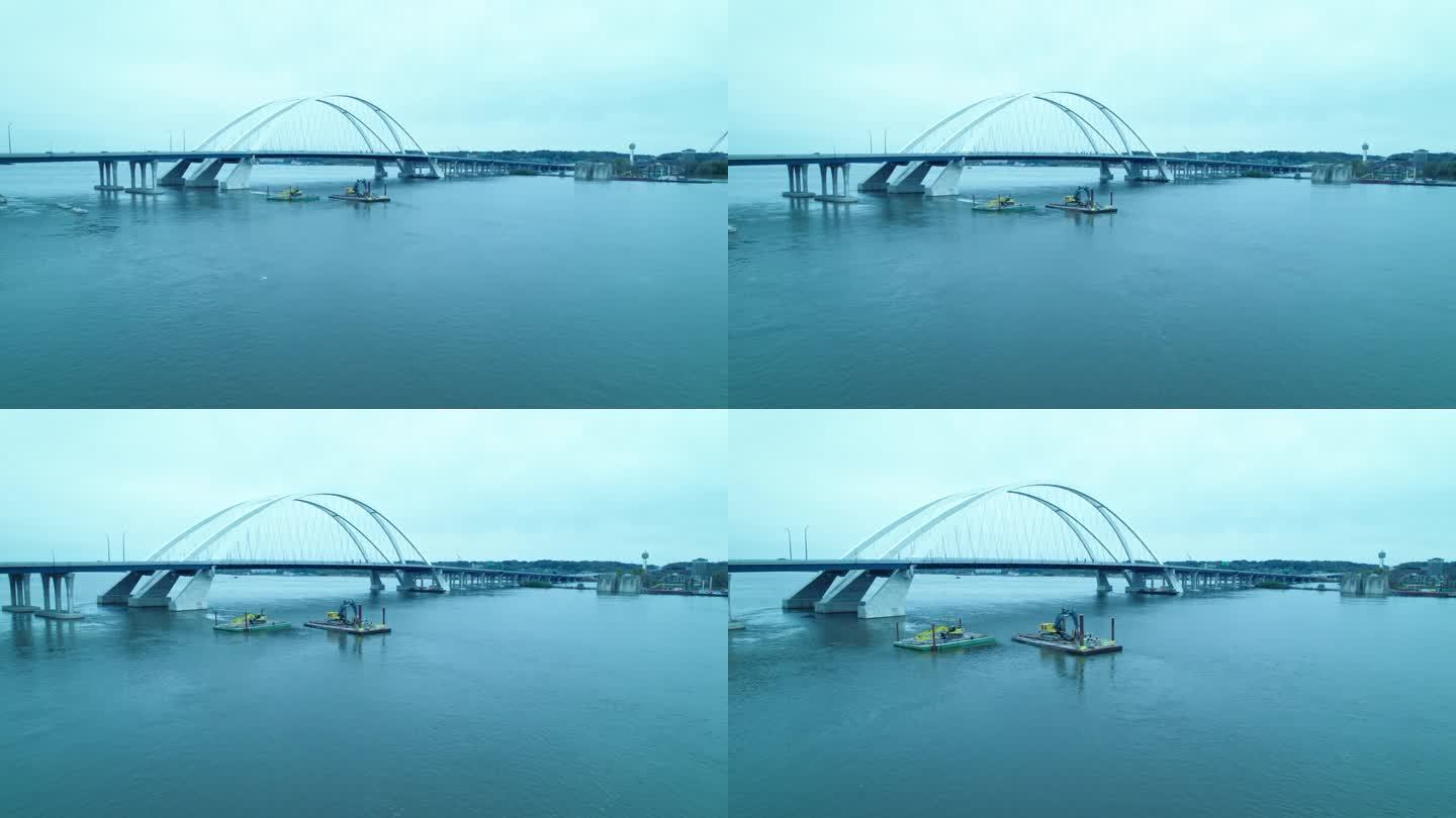 美国爱荷华州达文波特百年大桥上的密西西比河浮船坞浮桥上的建筑机械的航拍。