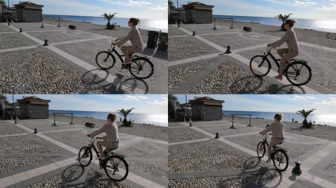 年轻女子沿着海滨步道骑自行车