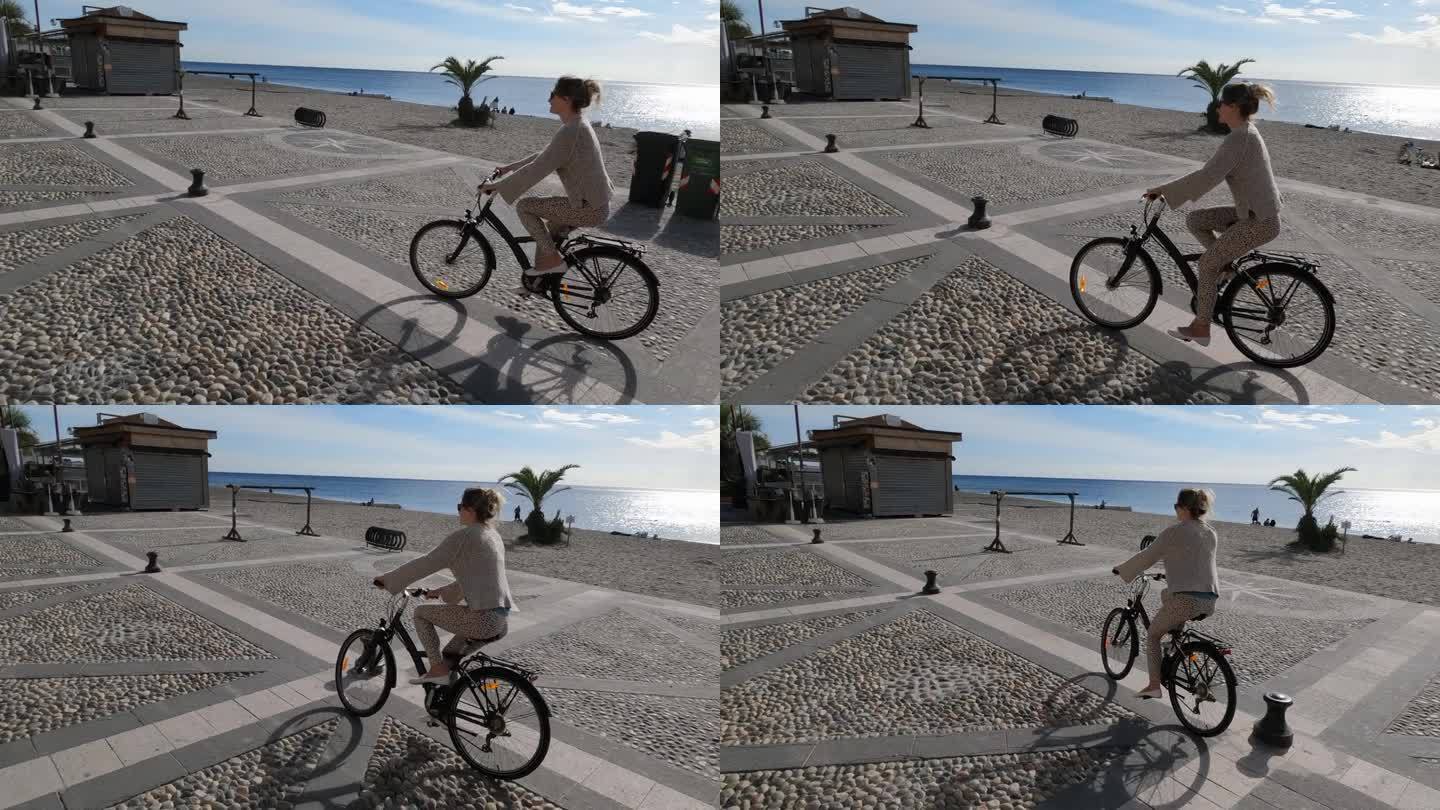 年轻女子沿着海滨步道骑自行车