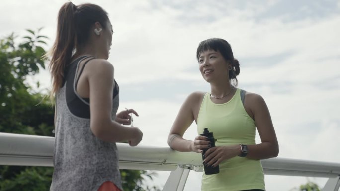 两个年轻的亚洲女人在公园户外运动时聊天