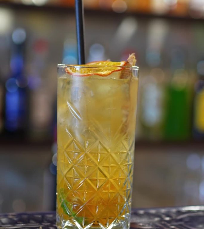 在马耳他的一个酒吧柜台上，有纹理的玻璃杯里装着清爽的生姜柠檬水鸡尾酒