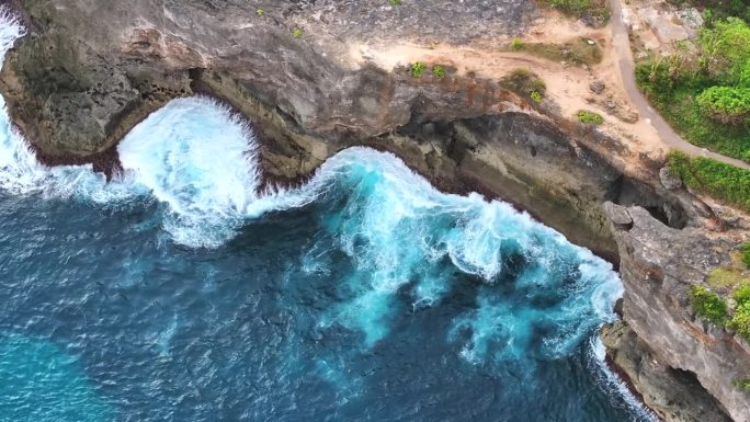 鸟瞰特写镜头，海浪冲击着印尼巴厘岛努沙佩尼达岛沿岸的岩石