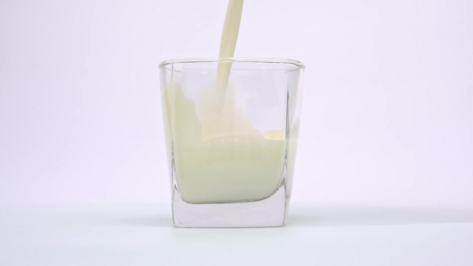 把牛奶倒进杯子里。喝牛奶养生的理念。慢动作
