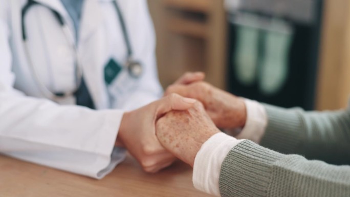 在诊所里，医生、老人和老人在近距离的镜头中牵手，寻求支持、咨询或护理。医生，护士和老年病人同情，善良