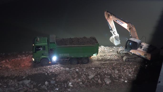 夜晚湖边施工渣土车清运挖掘机