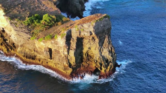 鸟瞰特写镜头，海浪冲击着印尼巴厘岛努沙佩尼达岛沿岸的岩石