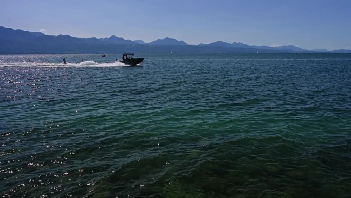 摩托艇上的人在日内瓦湖玩滑水。哎哟，瑞士洛桑。缓慢的运动。