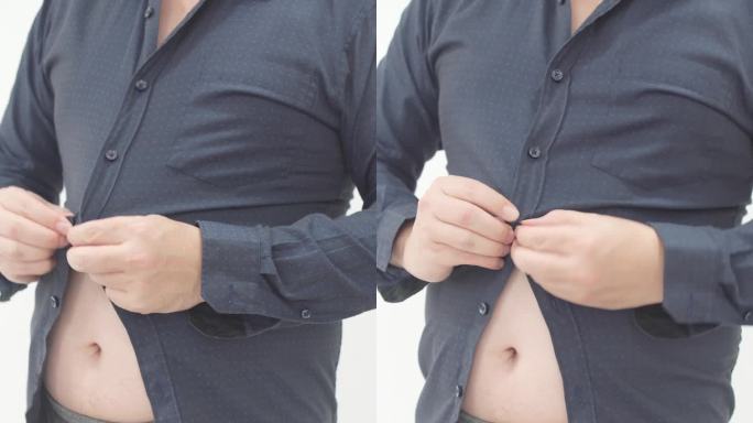 与肥胖的斗争:男人试图在大腰上扣衬衫-垂直视频。