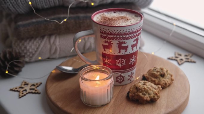 冬天窗台上的静物。红色陶瓷杯热咖啡放在窗台上。圣诞装饰的背景。温馨的家庭照片。采购产品温暖的羊毛针织
