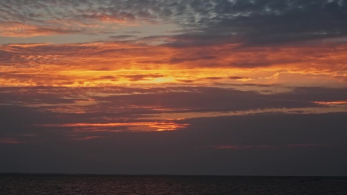 落日在河上的云中。阴天的夏夜