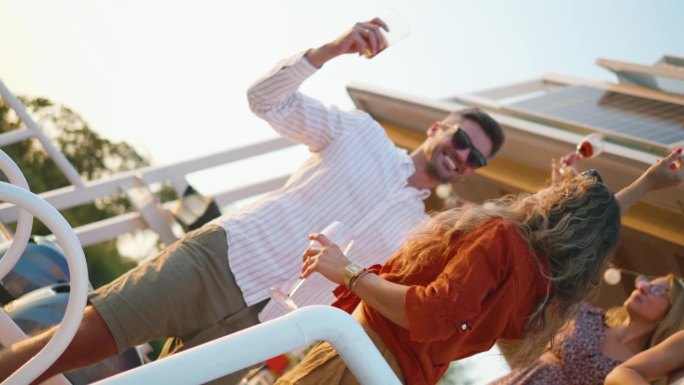 一对快乐的情侣和朋友在船上跳舞