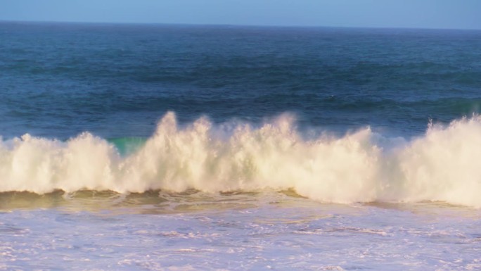 清晨的海浪以超级慢动作向浅滩翻滚。白色海沫