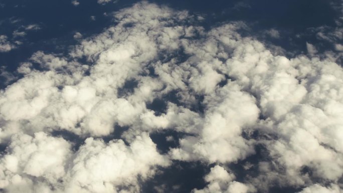 从飞机窗口鸟瞰地球。从飞行在地球上空的飞机上俯瞰地球上的云和海洋，以电影般的慢动作。