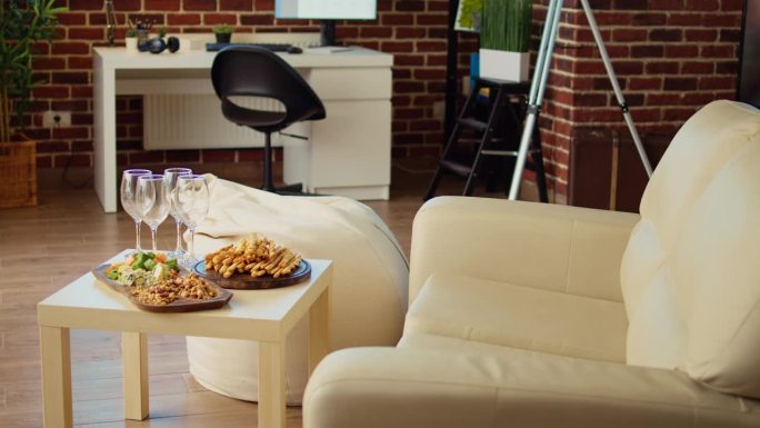 空的时尚舒适的公寓客厅，饼干，花生和奶酪在熟食板