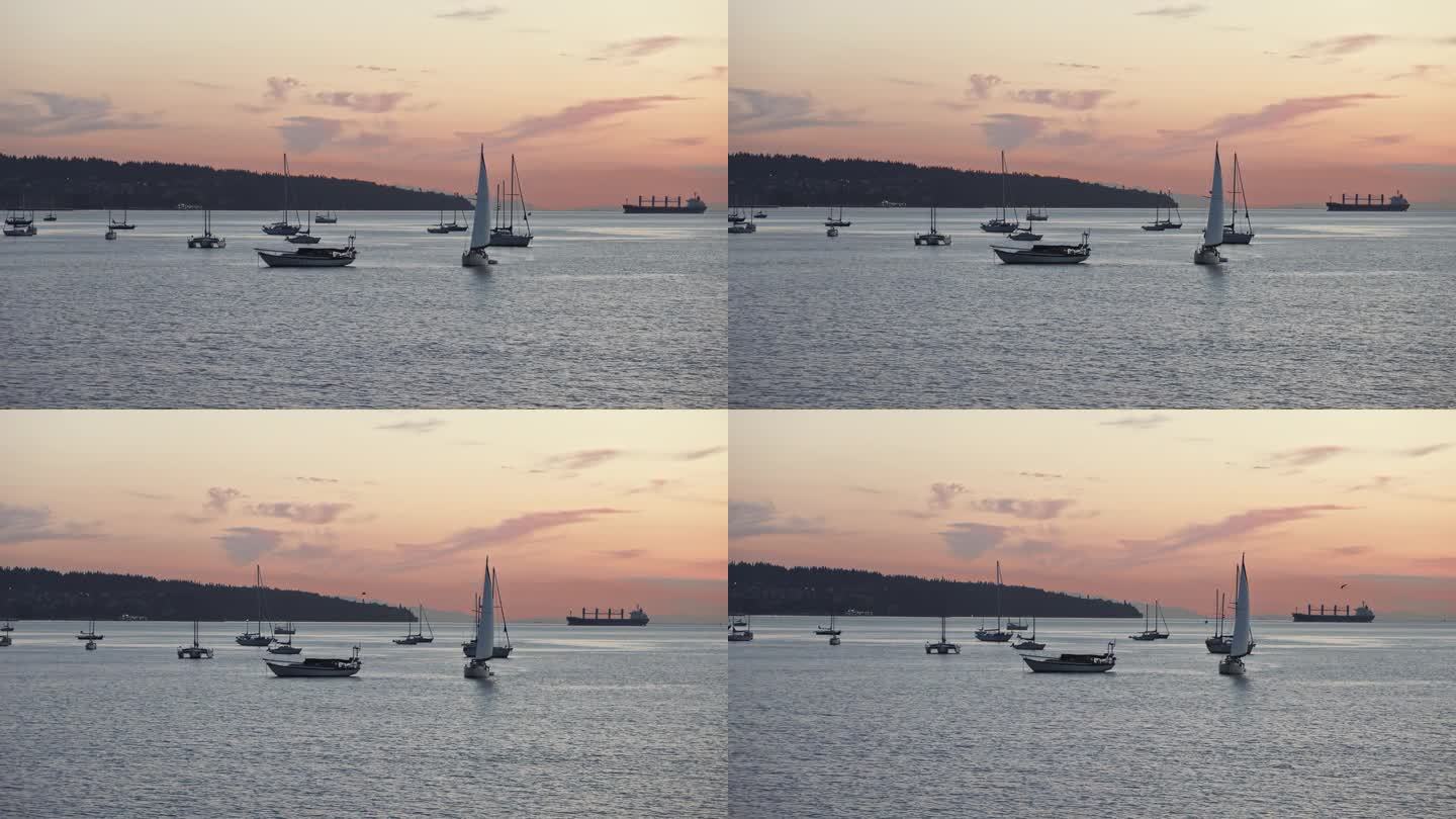 许多帆船在日落时平静的海面上航行