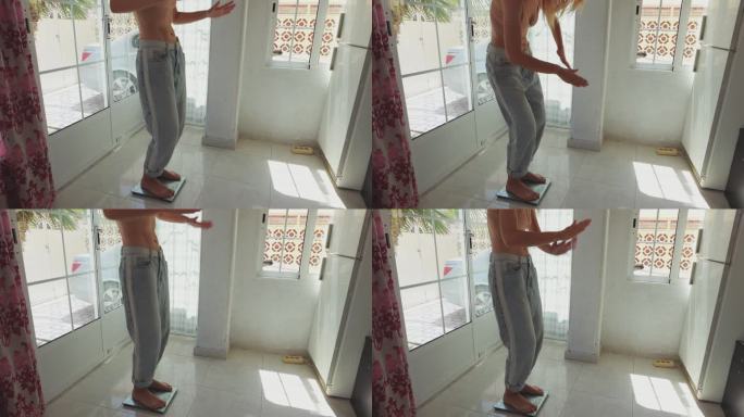 一个穿着大牛仔裤的瘦女孩站在家里的磅秤上跳舞。高品质4k画面