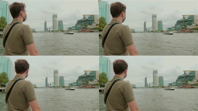 戴面具的男子探索城市滨河景观。
