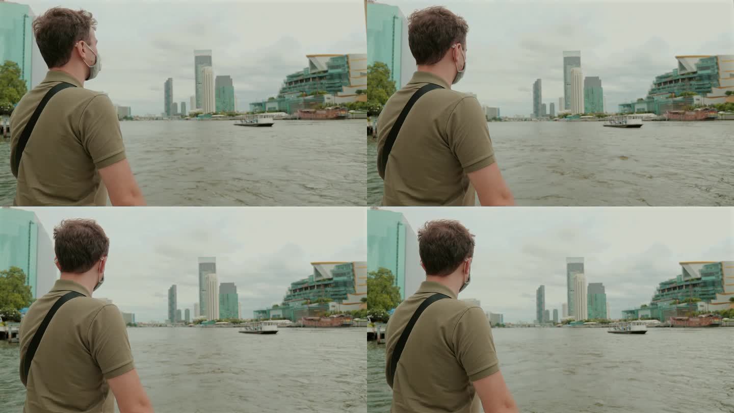 戴面具的男子探索城市滨河景观。