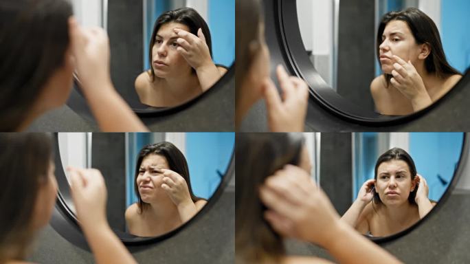 年轻漂亮的西班牙女人在浴室里对着镜子找痘痘