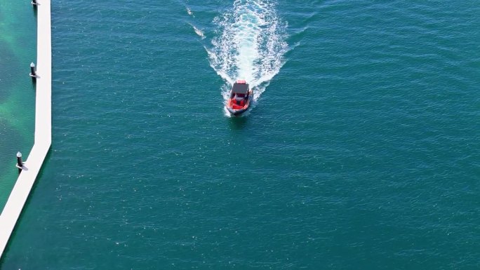 无人机推入倾斜向下，红黑相间的船用黑色篷布覆盖驶过航道码头