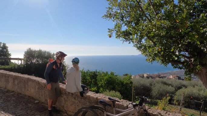 成熟的夫妇在石墙上骑自行车放松