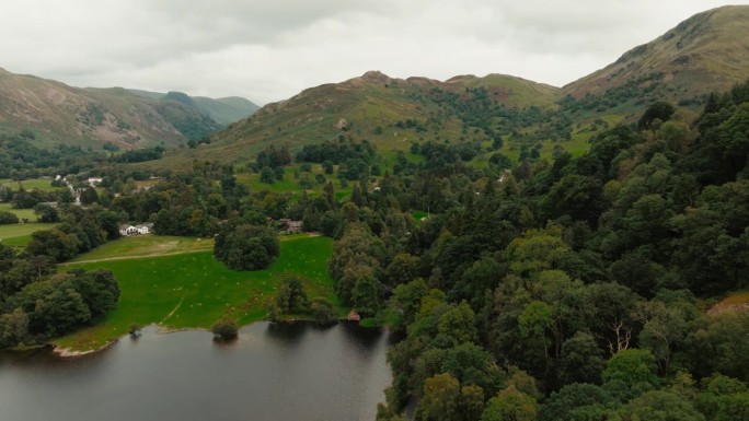 无人机飞向美丽的绿色山脉和草地景观，位于英国著名的湖区。