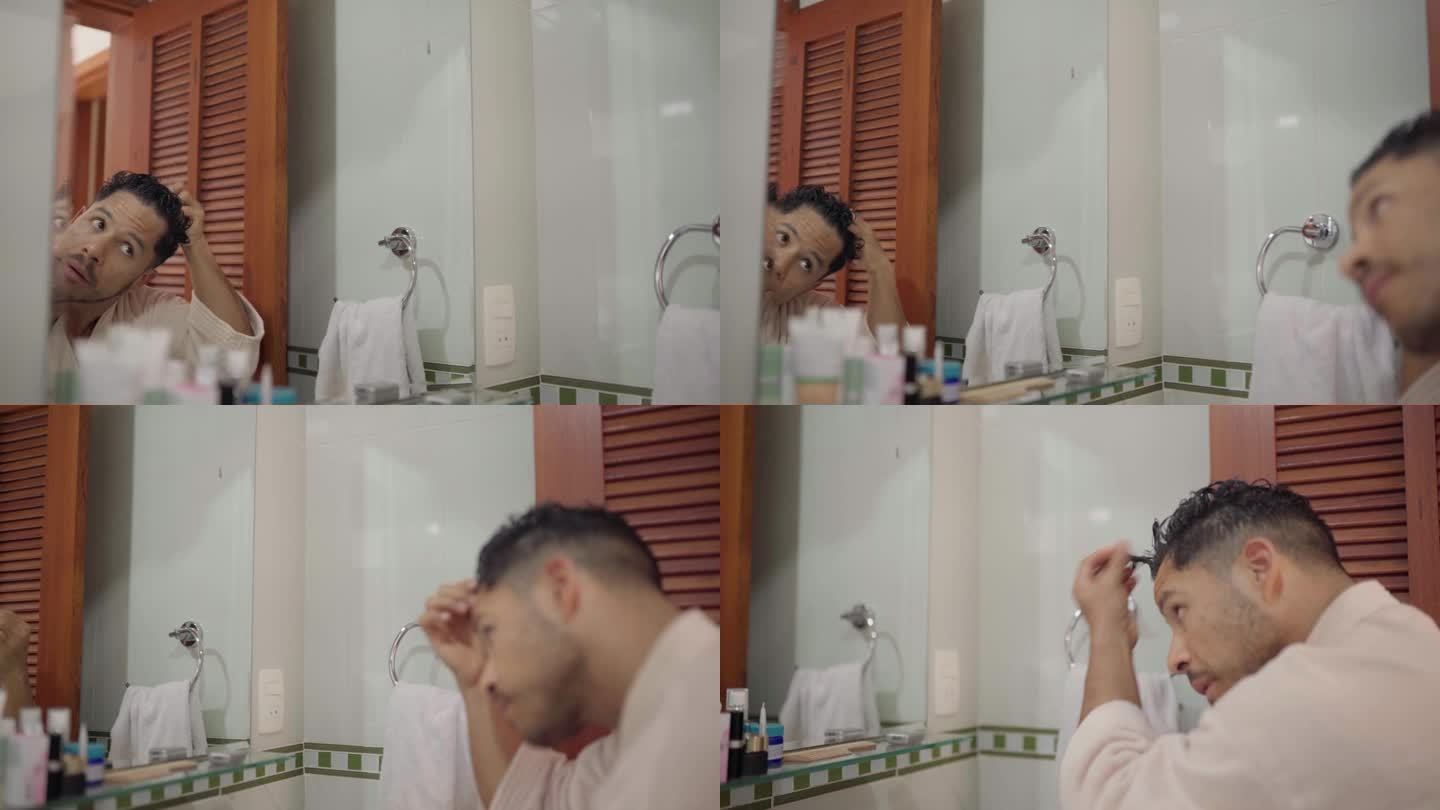 一个年轻人在淋浴后对着浴室的镜子做发型