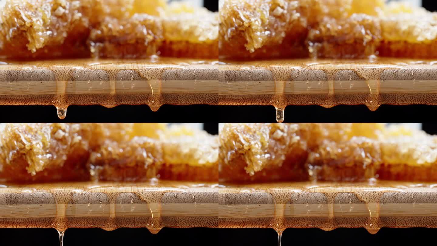 相机将焦点从背景中的蜂巢转移到前景中的蜜滴，特写镜头。