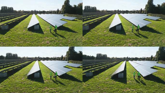 无人机拍摄的工程师在现场检查太阳能电池板产生可再生能源