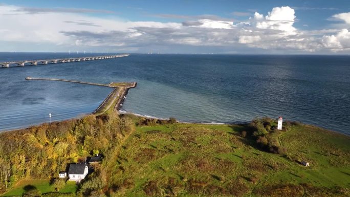 丹麦海岸线的航拍画面，Storebælt大桥横跨地平线，连接两个海岸和克努德塞德灯塔。克努德塞德灯塔