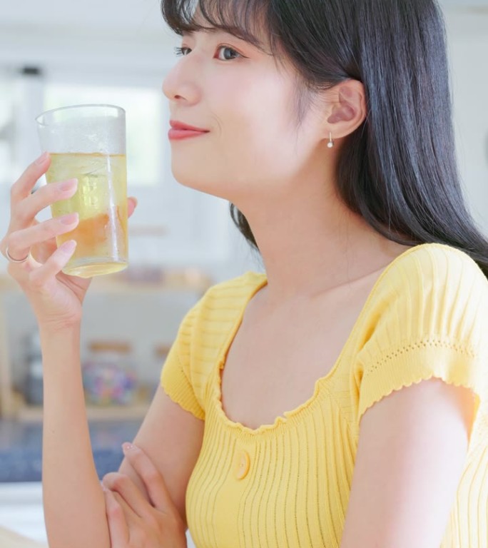 亚洲女人愉快地喝冰水