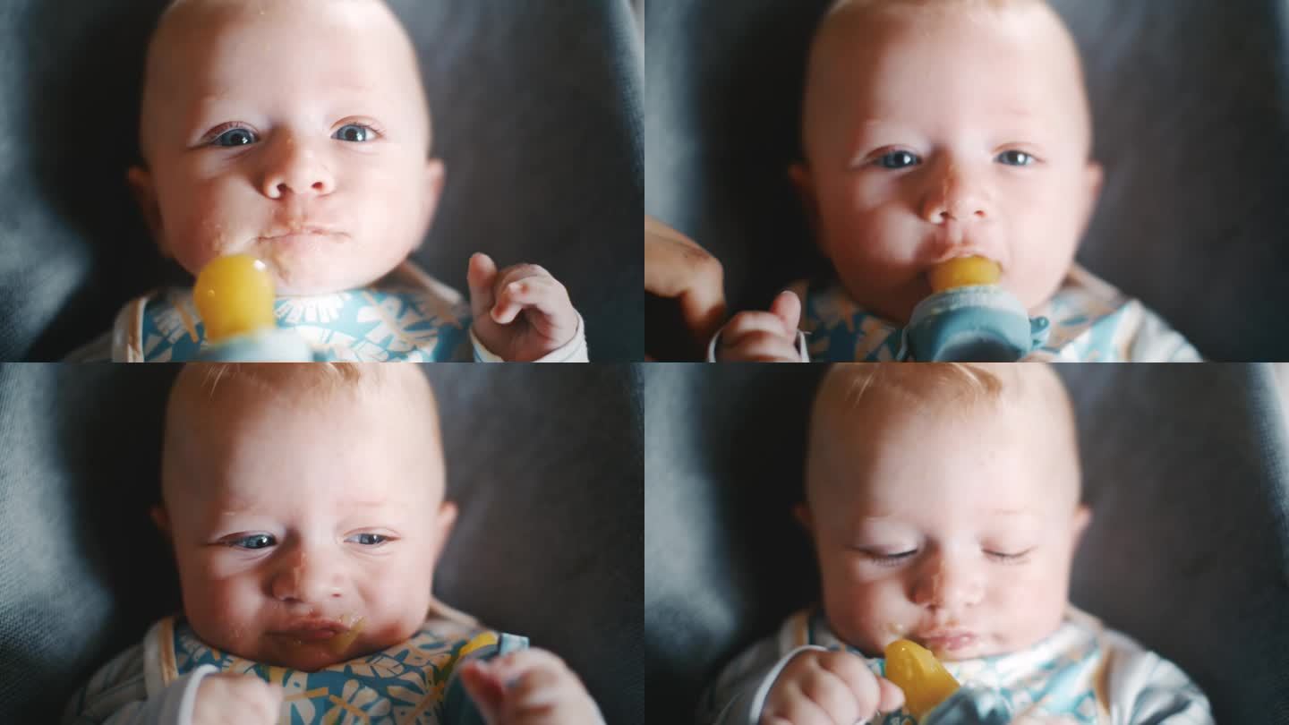 手持拍摄可爱的小男孩在家里的保镖那里吃着奶嘴里的芒果泥。介绍固体。