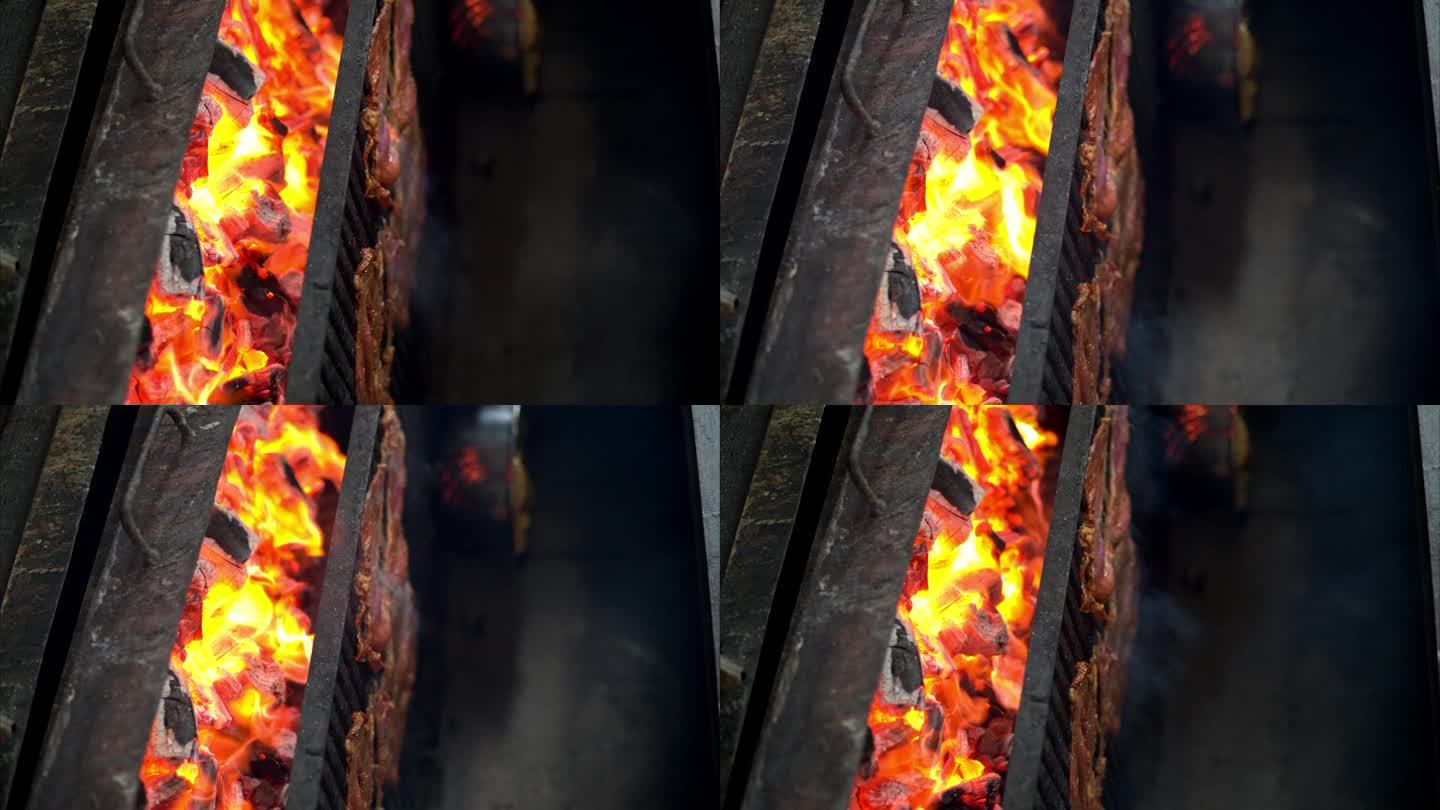 戴着手套的男性双手将肉牛排放在烧红燃烧的木炭烤架上的慢动作。垂直拍摄