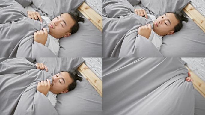 英俊，年轻的亚洲男子，惊恐的表情明显，躺在床上盖着毯子，害怕的早晨醒来